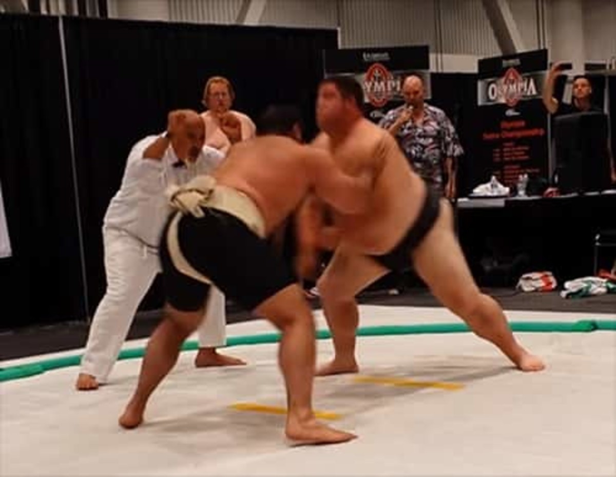 Strongman barrels through sumo wrestler